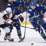 Vancouver Canucks' Adam Gaudette, right, skates with the puck past Arizona Coyotes' Brad Richardson during the second period of an NHL hockey game Wednesday, March 4, 2020, in Vancouver, British Columbia. (Darryl Dyck/The Canadian Press via AP)