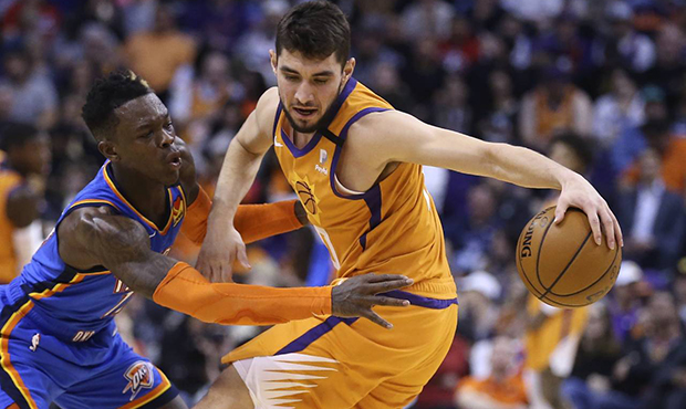 Oklahoma City Thunder guard Dennis Schroeder, left, reaches in to attempt a steal from Phoenix Suns...