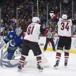 Vancouver Canucks goalie Thatcher Demko, left, gets up as Arizona Coyotes' Carl Soderberg (34), of Sweden, and Phil Kessel (81) celebrate Soderberg's goal during the first period of an NHL hockey game Wednesday, March 4, 2020, in Vancouver, British Columbia. (Darryl Dyck/The Canadian Press via AP)