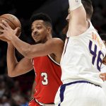 
              Portland Trail Blazers guard CJ McCollum, left, passes the ball on Phoenix Suns center Aron Baynes, right, during the first quarter of an NBA basketball game in Portland, Ore., Tuesday, March 10, 2020. (AP Photo/Steve Dykes)
            