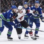 Vancouver Canucks' Oscar Fantenberg (5), of Sweden, checks Arizona Coyotes' Lawson Crouse (67) as Vancouver's Tanner Pearson (70) watches during the first period of an NHL hockey game Wednesday, March 4, 2020, in Vancouver, British Columbia. (Darryl Dyck/The Canadian Press via AP)