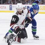 Arizona Coyotes' Phil Kessel (81) passes the puck from his knees while being checked by Vancouver Canucks' Elias Pettersson, of Sweden, during the first period of an NHL hockey game Wednesday, March 4, 2020, in Vancouver, British Columbia. (Darryl Dyck/The Canadian Press via AP)