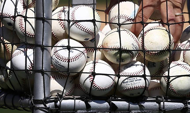Kansas City Royals coach John Mabry reaches for a few baseballs as he throws batting practice prior...