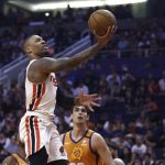 Portland Trail Blazers guard Damian Lillard, left, drives past Phoenix Suns forward Dario Saric, back right, to score during the first half of an NBA basketball game Friday, March 6, 2020, in Phoenix. (AP Photo/Ross D. Franklin)