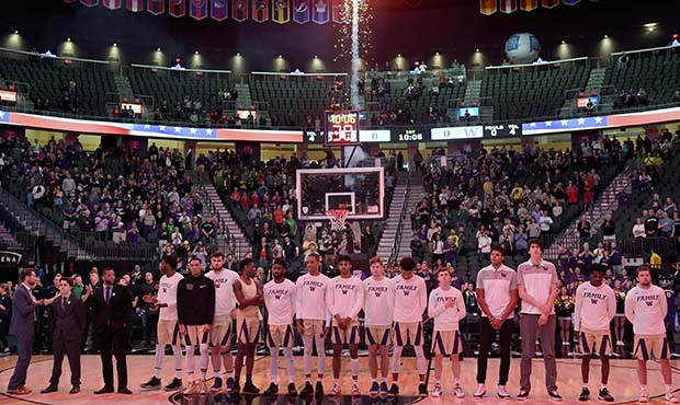 Pyrotechnics shoot into the air behind Washington Huskies players as the American national anthem i...
