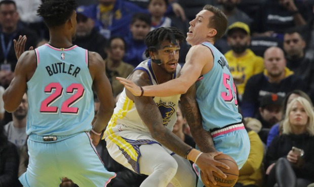 Golden State Warriors forward Marquese Chriss, middle, is defended by Miami Heat guard Duncan Robin...