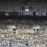 A banner reading "cardboard memorial" and "silent faces" are placed next to cardboard pictures of fans ahead the German first division Bundesliga football match Borussia Moenchengladbach and Bayer 04 Leverkusen on Saturday, May 23, 2020 in Moenchengladbach, western Germany. (Ina Fassbender/pool via AP)