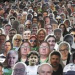 Cardboard pictures of fans are placed in the stands prior to the German Bundesliga soccer match between Borussia Moenchengladbach and Leverkusen, in Moenchengladbach, Germany, Saturday, May 23, 2020. (Ina Fassbender Pool Photo via AP)
