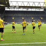 Dortmund's Erling Haaland, left, celebrates after scoring the opening goal during the German Bundesliga soccer match between Borussia Dortmund and Schalke 04 in Dortmund, Germany, Saturday, May 16, 2020. The German Bundesliga becomes the world's first major soccer league to resume after a two-month suspension because of the coronavirus pandemic. (AP Photo/Martin Meissner, Pool)