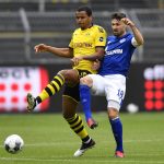 Dortmund's Manuel Akanji vies for the ball with Schalke's Daniel Caligiuri, right, during the German Bundesliga soccer match between Borussia Dortmund and Schalke 04 in Dortmund, Germany, Saturday, May 16, 2020. The German Bundesliga becomes the world's first major soccer league to resume after a two-month suspension because of the coronavirus pandemic. (AP Photo/Martin Meissner, Pool)