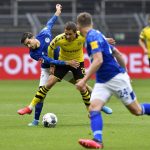 Schalke's Suat Serdar, left, fights for the ball with Dortmund's Thorgan Hazard during the German Bundesliga soccer match between Borussia Dortmund and Schalke 04 in Dortmund, Germany, Saturday, May 16, 2020. The German Bundesliga becomes the world's first major soccer league to resume after a two-month suspension because of the coronavirus pandemic. (AP Photo/Martin Meissner, Pool)