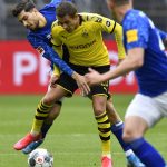 Schalke's Suat Serdar, left, fights for the ball with Dortmund's Thorgan Hazard during the German Bundesliga soccer match between Borussia Dortmund and Schalke 04 in Dortmund, Germany, Saturday, May 16, 2020. The German Bundesliga becomes the world's first major soccer league to resume after a two-month suspension because of the coronavirus pandemic. (AP Photo/Martin Meissner, Pool)