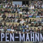 A banner reading "cardboard memorial" is placed next to cardboard pictures of fans ahead the German first division Bundesliga football match Borussia Moenchengladbach and Bayer 04 Leverkusen on Saturday, May 23, 2020 in Moenchengladbach, western Germany. (Ina Fassbender/pool via AP)