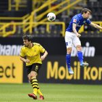 Schalke's Benito Raman, right, jumps for the ball with Dortmund's Mats Hummels during the German Bundesliga soccer match between Borussia Dortmund and Schalke 04 in Dortmund, Germany, Saturday, May 16, 2020. The German Bundesliga becomes the world's first major soccer league to resume after a two-month suspension because of the coronavirus pandemic. (AP Photo/Martin Meissner, Pool)