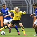 Dortmund's Erling Haaland vies for the ball with Schalke's Daniel Caligiuri, left, and Jean-Clair Todibo during the German Bundesliga soccer match between Borussia Dortmund and Schalke 04 in Dortmund, Germany, Saturday, May 16, 2020. The German Bundesliga becomes the world's first major soccer league to resume after a two-month suspension because of the coronavirus pandemic. (AP Photo/Martin Meissner, Pool)