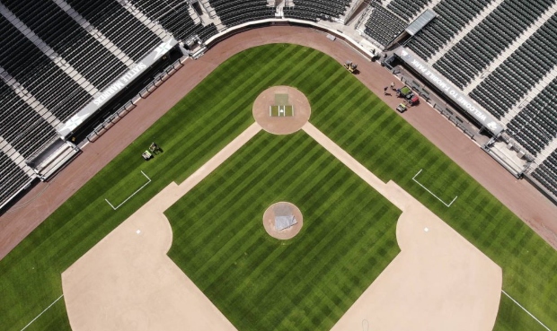 Grounds crew members mow as work continues to keep the Seattle Mariners' field in playing shape as ...