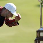 Daniel Berger examines the championship trophy after winning the Charles Schwab Challenge golf tournament after a playoff round at the Colonial Country Club in Fort Worth, Texas, Sunday, June 14, 2020. (AP Photo/David J. Phillip)