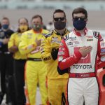 Erik Jones, right, and other drivers stand for the national anthem before a NASCAR Cup Series auto race Sunday, June 14, 2020, in Homestead, Fla. (AP Photo/Wilfredo Lee)
