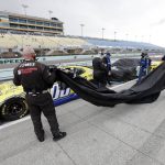 Crew members cover the car of Quinn Houff (00) during a weather delay at a NASCAR Cup Series auto race Sunday, June 14, 2020, in Homestead, Fla. (AP Photo/Wilfredo Lee)