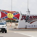 
              Race fans fly Confederate battle flags and United States flags as they drive by the entrance to Talladega Superspeedway prior to a NASCAR Cup Series auto race in Talladega Ala., Sunday, June 21, 2020. (AP Photo/John Bazemore)
            
