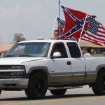Race fans fly Confederate battle flags and a United States flag as they drive by Talladega Superspeedway prior to a NASCAR Cup Series auto race in Talladega Ala., Sunday, June 21, 2020. (AP Photo/John Bazemore)