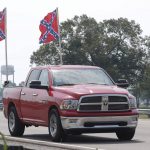 A truck flying Confederate flags passes by the Talladega Superspeedway prior to the NASCAR Cup Series auto race at the in Talladega Ala., Sunday June 21, 2020 (AP Photo/John Bazemore)