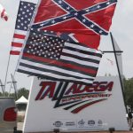 
              Race fans fly Confederate battle flags and United States flags as they drive by the entrance to Talladega Superspeedway prior to a NASCAR Cup Series auto race in Talladega Ala., Sunday, June 21, 2020. (AP Photo/John Bazemore)
            