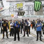 Drivers and crew members stand for the national anthem before a NASCAR Cup Series auto race Sunday, June 14, 2020, in Homestead, Fla. (AP Photo/Wilfredo Lee)