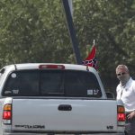 A race fan flying a Confederate battle flag passes through a checkpoint as he enters Talladega Superspeedway for a NASCAR Cup Series auto race in Talladega, Ala., Sunday, June 21, 2020. (AP Photo/John Bazemore)