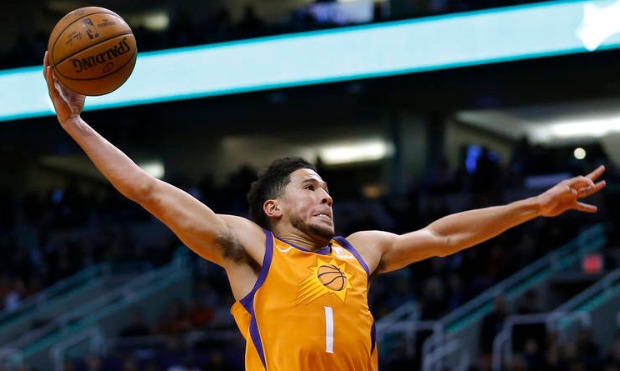 Phoenix Suns guard Devin Booker dunks over Dallas Mavericks forward Kristaps Porzingis (6) during t...