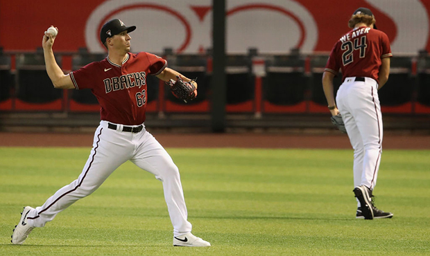 Pitcher Taylor Widener #62 of the Arizona Diamondbacks warms up in the outfield as he participates ...