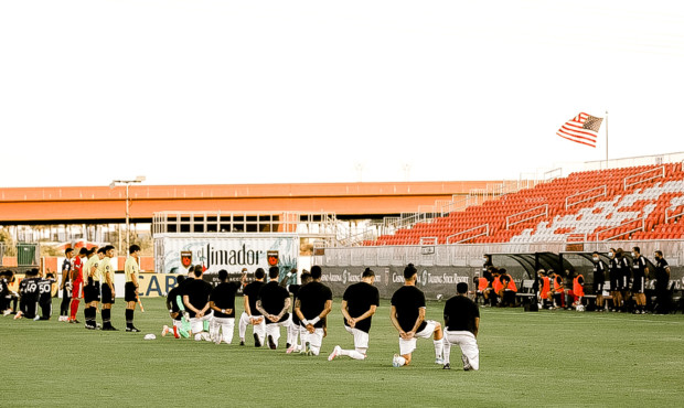 Phoenix Rising FC players take a knee before first game back