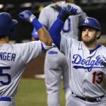 Los Angeles Dodgers' Max Muncy (13) celebrates his home run against the Arizona Diamondbacks with Cody Bellinger (35) during the sixth inning of the Diamondbacks' home-opener baseball game Thursday, July 30, 2020, in Phoenix. (AP Photo/Ross D. Franklin)