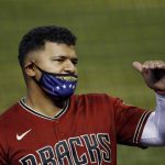 Arizona Diamondbacks' Eduardo Escobar talks to a coach in the stands during a baseball training camp intrasquad scrimmage Sunday, July 12, 2020, in Phoenix. (AP Photo/Ross D. Franklin)