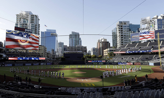 The Arizona Diamondbacks and the San Diego Padres stand during the national anthem before a basebal...