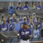 Los Angeles Dodgers' Justin Turner warms up in front of cardboard cutouts of fans before an exhibition baseball game against the Arizona Diamondbacks Monday, July 20, 2020, in Los Angeles. (AP Photo/Marcio Jose Sanchez)
