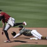 San Diego Padres' Josh Naylor, bottom, slides past second base on a steal attempt next to Arizona Diamondbacks second baseman Ketel Marte during the seventh inning of a baseball game in San Diego, Sunday, July 26, 2020. Naylor was out. (AP Photo/Kelvin Kuo)