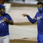 While wearing face coverings, Los Angeles Dodgers' pitcher Kenley Jansen, right, talks with Dodgers' pitcher Pedro Baez, left, prior to an Arizona Diamondbacks' opening day baseball game Thursday, July 30, 2020, in Phoenix. (AP Photo/Ross D. Franklin)