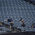 The San Diego Padres field crew sit in the stands waiting for the end of the third inning of a baseball game against the Arizona Diamondbacks in San Diego, Saturday, July 25, 2020. (AP Photo/Kelvin Kuo)