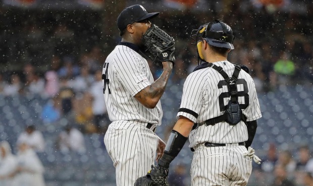 New York Yankees relief pitcher Aroldis Chapman, left, talks to catcher Austin Romine during the ni...