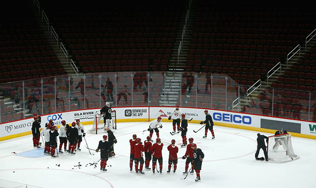 The Arizona Coyotes players and coaches pause on the ice during NHL hockey practice at Gila River A...