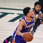 Phoenix Suns' Devin Booker (1) draws a foul from Los Angeles Clippers' Paul George (13) during an NBA basketball game Tuesday, Aug. 4, 2020, in Lake Buena Vista, Fla. (Kevin C. Cox/Pool Photo via AP)