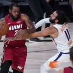 Miami Heat guard Andre Iguodala, left, drives to the basket as Phoenix Suns' Ricky Rubio (11) defends during the first half of an NBA basketball game, Saturday, Aug. 8, 2020 in Lake Buena Vista, Fla. (AP Photo/Ashley Landis, Pool)