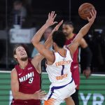 Miami Heat's Kelly Olynyk (9) defends Phoenix Suns' Devin Booker (1) during the first half of an NBA basketball game, Saturday, Aug. 8, 2020 in Lake Buena Vista, Fla. (AP Photo/Ashley Landis, Pool)
