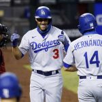 
              Los Angeles Dodgers' Chris Taylor (3) smiles as he celebrates his three-run home run against the Arizona Diamondbacks with teammate Kiké Hernandez (14) as Diamondbacks catcher Carson Kelly, left, looks to the dugout during the eighth inning of a baseball game Saturday, Aug. 1, 2020, in Phoenix. (AP Photo/Ross D. Franklin)
            