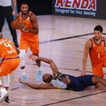 Phoenix Suns' Mikal Bridges (25) picks up the ball as Indiana Pacers' T.J. Warren, center bottom, goes down during the second quarter of an NBA basketball game Thursday, Aug. 6, 2020, in Lake Buena Vista, Fla. (Kevin C. Cox/Pool Photo via AP)