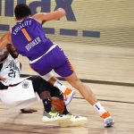 Los Angeles Clippers Patrick Beverley (21) falls to the ground with Phoenix Suns Devin Booker during the first half of an NBA basketball game Tuesday, Aug. 4, 2020, in Lake Buena Vista, Fla. (Kevin C. Cox/Pool Photo via AP)
