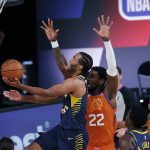 Indiana Pacers' T.J. Warren, left, attacks the basket as Phoenix Suns' Deandre Ayton (22) defends during the first half of an NBA basketball game Thursday, Aug. 6, 2020, in Lake Buena Vista, Fla. (Kevin C. Cox/Pool Photo via AP)