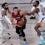 Miami Heat's Duncan Robinson (55) is defended by Phoenix Suns' Ricky Rubio, left, and Mikal Bridges, right, during the first half of an NBA basketball game, Saturday, Aug. 8, 2020 in Lake Buena Vista, Fla. (AP Photo/Ashley Landis, Pool)