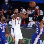 Phoenix Suns forward Mikal Bridges (25) passes the ball as Philadelphia 76ers guard Alec Burks (20) and 76ers guard Matisse Thybulle, right, defend during the first half of an NBA basketball game Tuesday, Aug. 11, 2020, in Lake Buena Vista, Fla. (AP Photo/Ashley Landis, Pool)